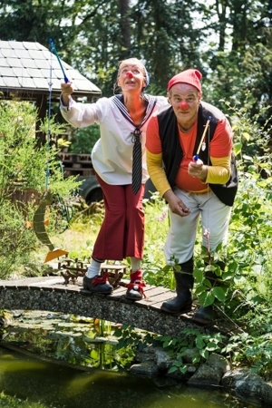 Zwei Personen mit Clownsnasen in einem Garten